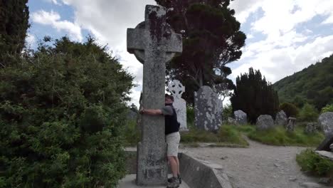 Irland-Glendalough-Keltischer-Klostermann-Umarmt-Hochkreuz