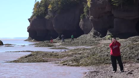 Canada-Woman-In-Red-Takes-A-Photograph-At-Hopewell-Rocks