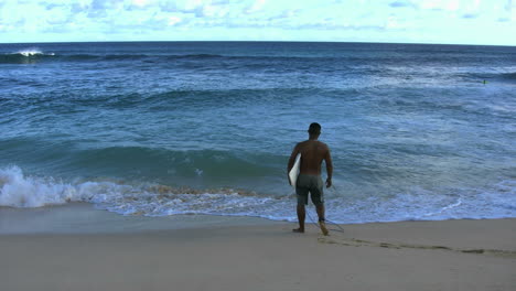 Surfista-En-La-Playa-De-Arena-De-Oahu-Entra-Al-Agua