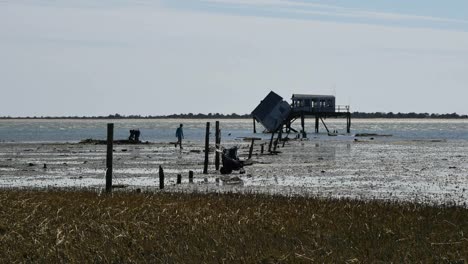 Virginia-Shack-And-People-At-Edge-Of-Water