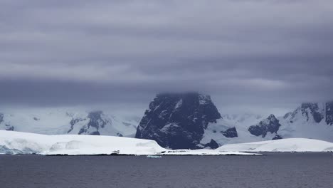 Pico-De-Roca-Antártica-Y-Nieve-En-La-Distancia