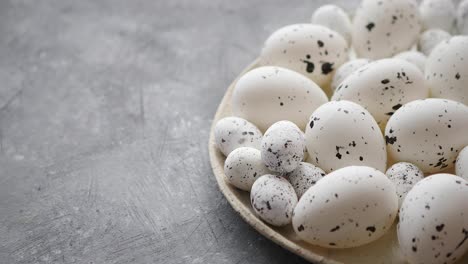 Composition-of-white-traditional-dotted-Easter-eggs-in-white-ceramic-plate