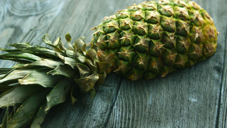 Half-of-pineapple-on-wooden-table