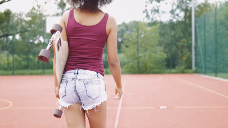 Mädchen-Mit-Skateboard-Auf-Sportplatz