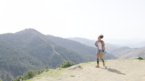 Female-backpacker-walking-on-top-of-mountain