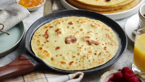 Healthy-homemade-pancake-on-stone-frying-pan-placed-on-table