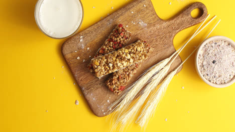Cereal-bars-and-oats-on-wooden-board