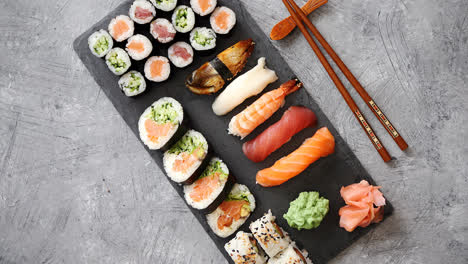 Composition-of-different-kinds-of-sushi-rolls-placed-on-black-stone-board