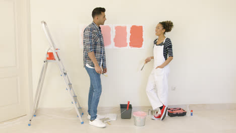 Young-couple-trying-to-decide-on-a-paint-color