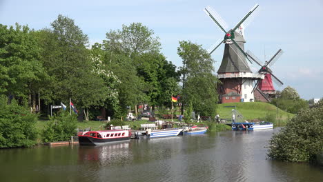 Germany-two-windmills-and-a-canal-with-boats-at-Greetsiel