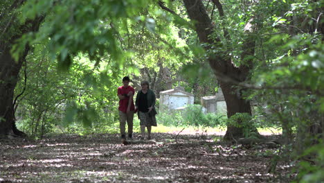 Louisiana-woman-and-boy-walking-from-tombs-in-woods
