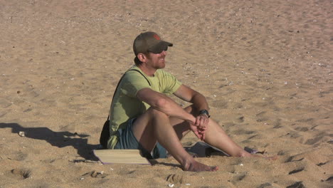 Hawaii-Kauai-man-seated-on-sandy-beach-2