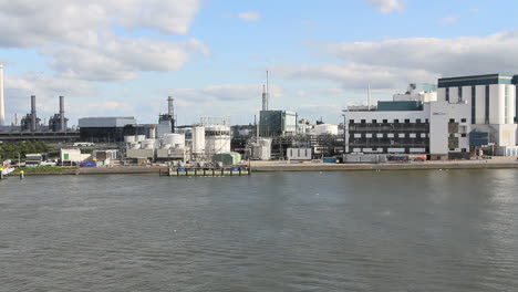 Netherlands-Rotterdam-tug-and-long-tanker-passes-oil-refinery