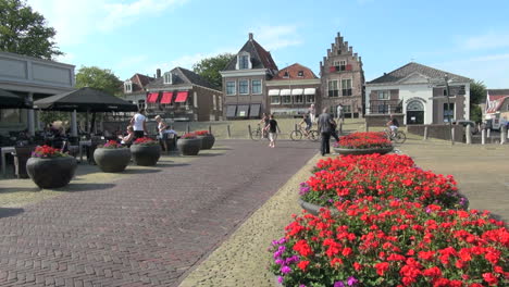 Holanda-Edam-Flores-Rojas-En-Jardineras-Redondas-En-Cuadrado