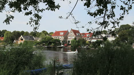 Netherlands-skiff-passes-canal-side-village-2