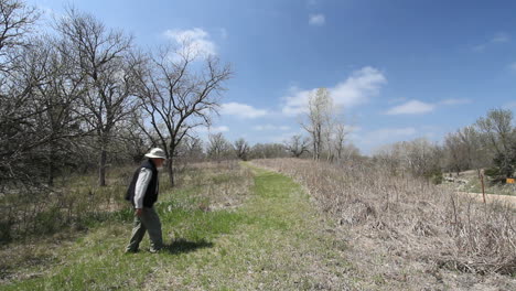 Kansas-Alcove-Spring-man-walks-near-bare-trees