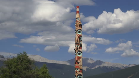 Canada-Alberta-Jasper-totem-pole-with-clouds-and-mountains