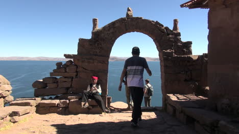 Peru-Taquile-people-walk-and-take-photos-near-stone-arch-17