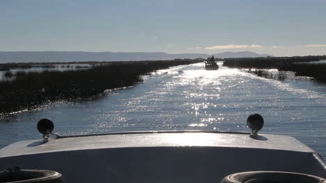 Peru-Lake-Titicaca-Boot-Verfolgt-Ein-Anderes-Boot-Durch-Glitzerndes-Wasser