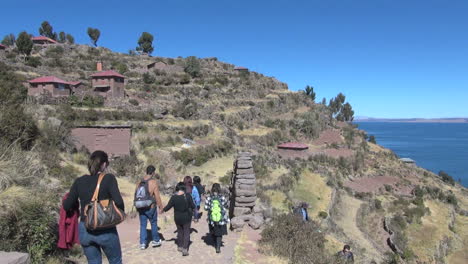 Peru-Taquile-Hügeltouristen-Gehen-Durch-Die-Bogenseitenansicht-27