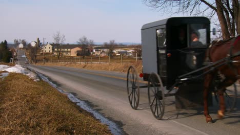 Un-Carro-De-Caballos-Amish-Viaja-A-Lo-Largo-De-Una-Carretera-En-La-Zona-Rural-De-Pensilvania-1