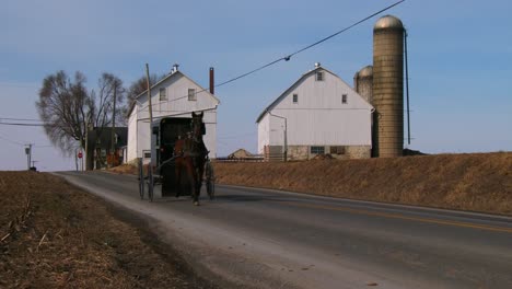 Un-Carro-De-Caballos-Amish-Viaja-A-Lo-Largo-De-Una-Carretera-En-La-Zona-Rural-De-Pensilvania-2