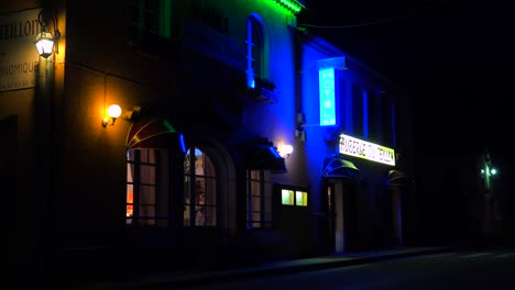 A-small-French-hotel-at-night-with-neon-sign-flashing