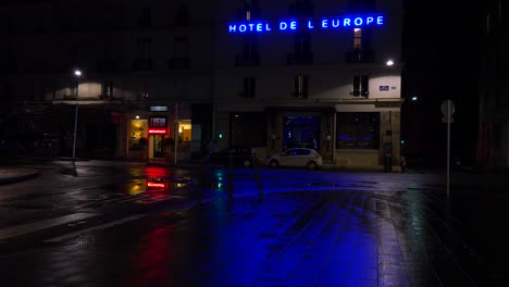 A-hotel-sign-is-reflected-in-rainy-streets-of-Paris-or-France