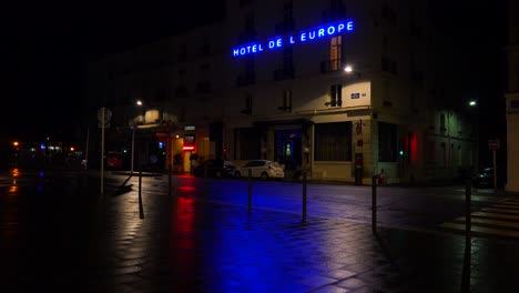 A-hotel-sign-is-reflected-in-rainy-streets-of-Paris-or-France-with-a-light-on-upstairs-1