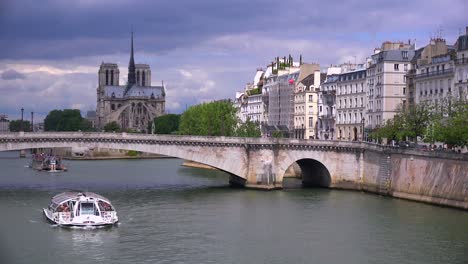Ein-Flussschiff-Fährt-Unter-Brücken-In-Der-Nähe-Der-Kathedrale-Notre-Dame-In-Paris-Hindurch-1
