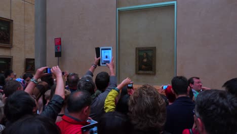 Tourists-crowd-around-the-Mona-Lisa-painting-in-the-Louvre-Museum-in-parís