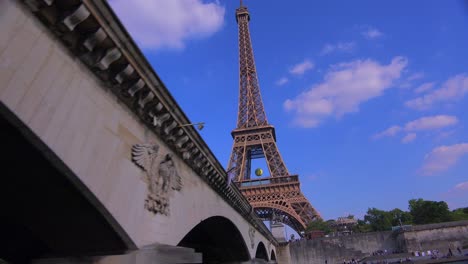 Punto-De-Vista-Desde-Un-Barco-Fluvial-Pasando-Por-Debajo-De-Un-Puente-De-La-Torre-Eiffel-De-París