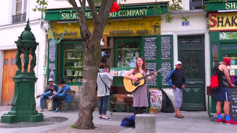 A-girl-plays-folk-music-outside-a-bookstore-and-cafe-in-Paris