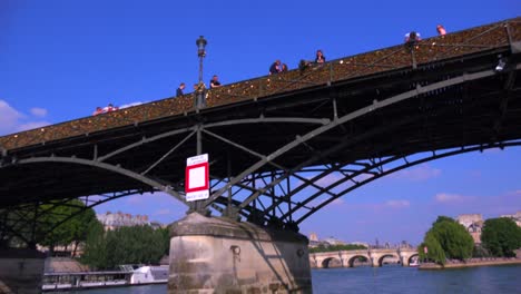 A-point-of-view-of-the-Pont-Des-Artes-from-a-bateaux-mouche-riverboat-along-the-Seine-River-in-Paris