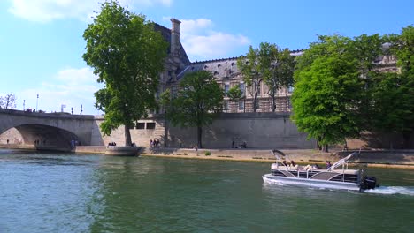 Ein-Blick-Auf-Ein-Kleines-Boot-Von-Einem-Bateaux-Mouche-Riverboat,-Der-Entlang-Der-Seine-In-Paris-Fährt