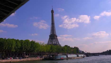 A-point-of-view-of-the-Eiffel-Tower-from-a-bateaux-mouche-riverboat-traveling-along-the-Seine-Río-in-París