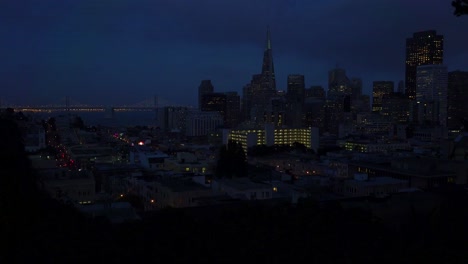 Establishing-shot-of-San-Francisco-California-at-night-with-Bay-Bridge-background