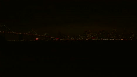 Establishing-shot-of-San-Francisco-California-at-night-with-Bay-Bridge-foreground