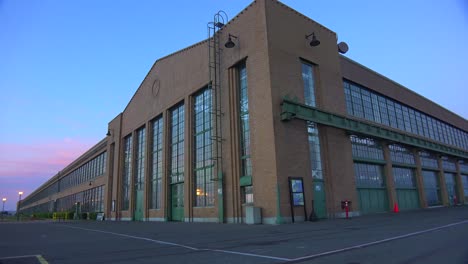 Wide-shot-of-a-large-warehouse-or-factory-at-dusk-or-sunset