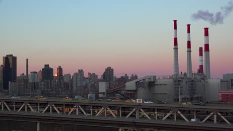 Abenddämmerung-Blick-über-Queens-Nach-Upper-Manhattan-In-New-York-City-Mit-Kraftwerksschornsteinen-Und-Queensboro-Bridge
