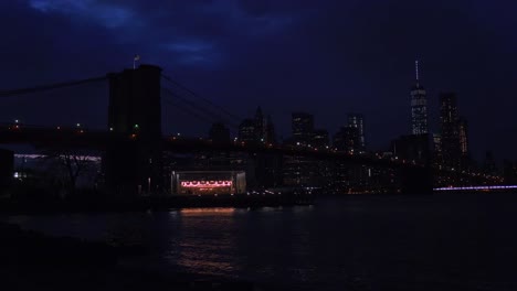 Die-Skyline-Von-New-York-City-Mit-Der-Brooklyn-Bridge-Im-Vordergrund-Bei-Nacht