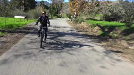 Ein-Mann-In-Lederjacke-Fährt-Mit-Einem-Motorisierten-Fahrrad-über-Eine-Landstraße