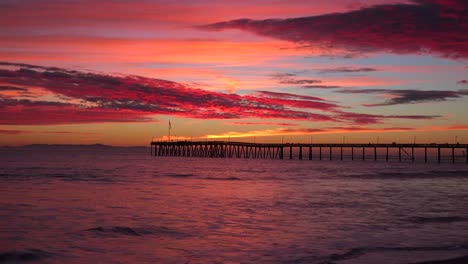 Eine-Wunderschöne-Rot-orangefarbene-Sonnenuntergangsküste,-Die-Entlang-Der-Kalifornischen-Küste-Mit-Dem-Entfernten-Ventura-Pier-Aufgenommen-Wurde