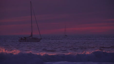 A-sailboat-passes-at-sunset-along-a-Southern-California-beach