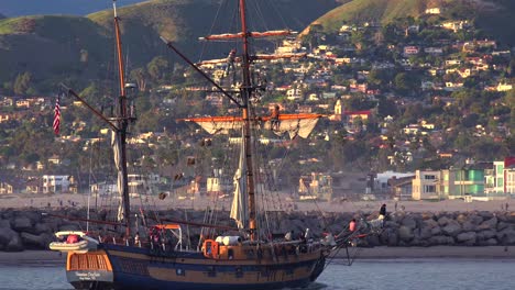 Ein-Großes-Klipperschiff-Segelt-Bei-Sonnenuntergang-Mit-Der-Stadt-Ventura-Kalifornien-In-Der-Ferne