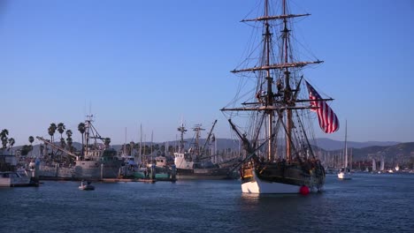 Sailors-stand-on-the-mast-of-a-tall-historic-clipper-ship-as-it-sails-in-the-harbor-in-Ventura-California