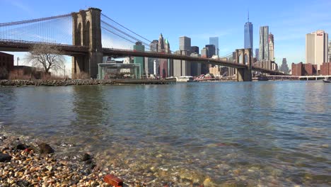 El-Nivel-Del-Agua-Que-Establece-La-Toma-Del-Distrito-Financiero-De-La-Ciudad-De-Nueva-York-Con-El-Puente-De-Brooklyn-En-Primer-Plano-Y-Los-Barcos-Que-Pasan-Por-Debajo-De-1