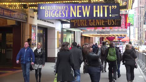 Fußgänger-Gehen-Unter-Broadways-Schildern-Hindurch,-Die-Den-Neuesten-Bühnenhit-Ankündigen