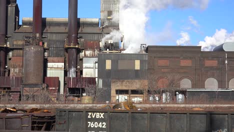 Global-warming-is-suggested-by-shots-of-a-steel-mill-belching-smoke-into-the-air-with-railcars-foreground-2