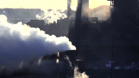Establishing-shot-of-a-busy-steel-mill-with-smoke-belching-suggests-global-warming